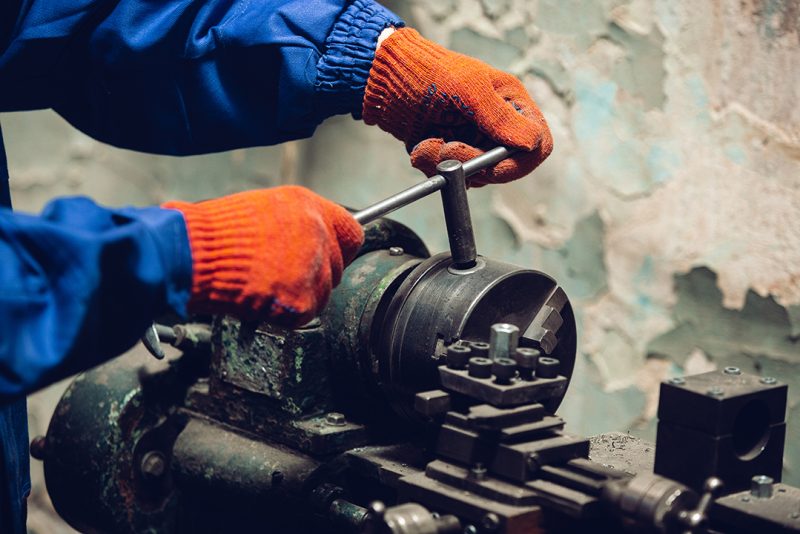 Closeup of repairman in uniform, professional builder working using construction equipment. Process of building, apartment renovation, repairing, building. Coloring, measuring, preparing the base.